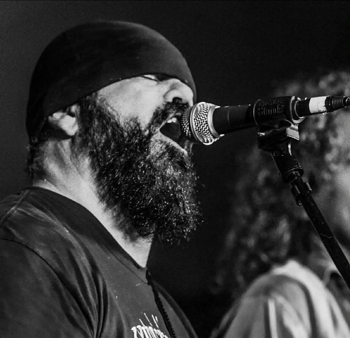 Mark Moffatt singing live, a black-and-white close-up — The Glorious Heydays